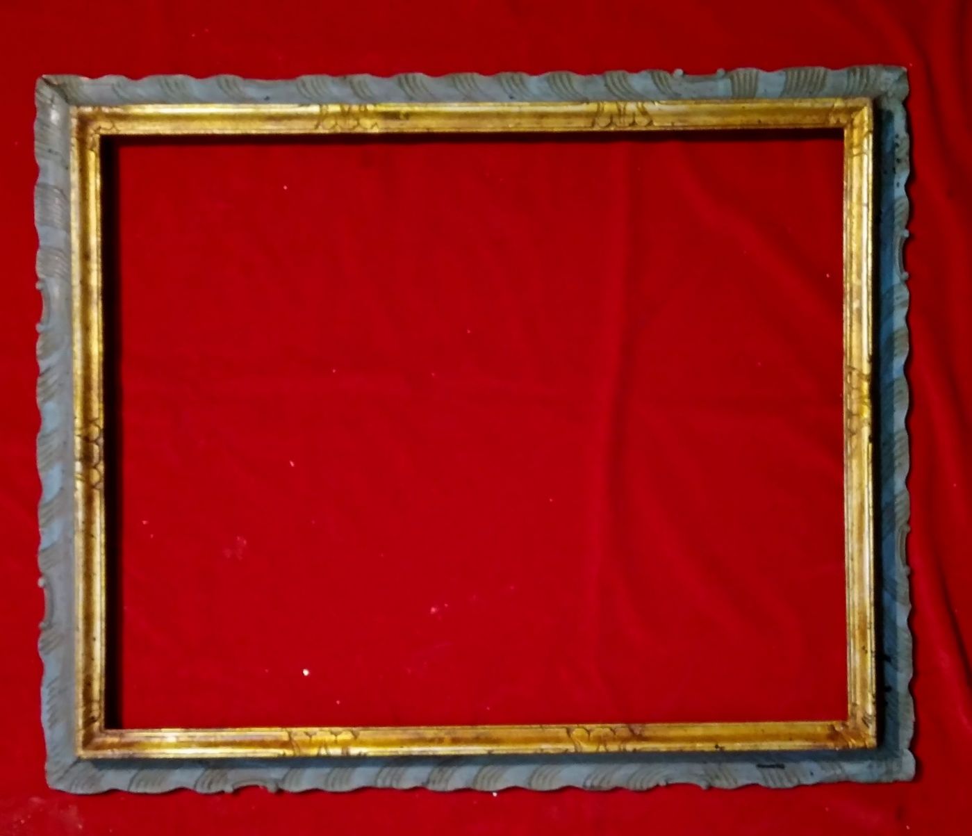 cornice in legno intagliato dorato e laccato verde/azzurro.Bordo curvilineo ed intagliato ad onde.XIX° sec. luce 56x70 est.68x85